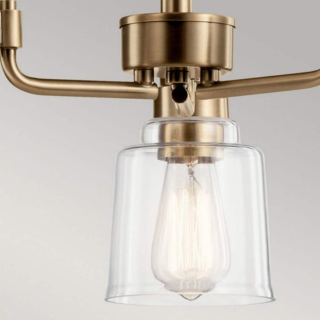 The Aivian 3 Light Chandelier in Weathered Brass radiates modern elegance with its clear glass shades that encase vintage-style exposed filament bulbs, all set against a neutral gray background. The weathered brass finish adds a touch of industrial aesthetics to any space.