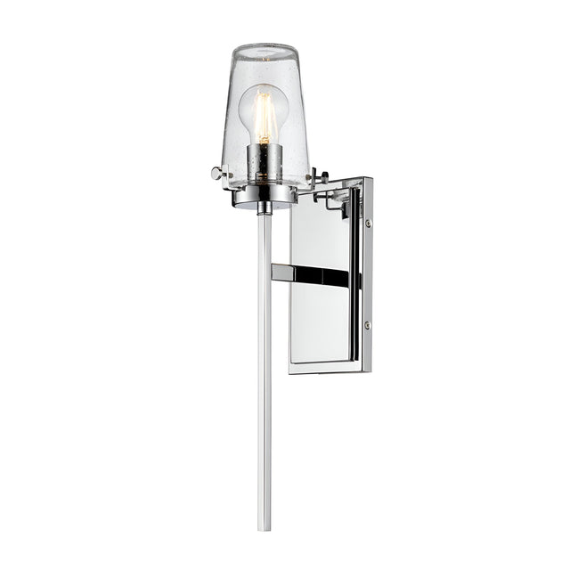 The Alton 1 Light Wall Light - Chrome features a sleek, minimalist design with a chrome finish and clear glass shade that highlights the visible bulb. Its modern appeal is enhanced by being mounted on a rectangular backplate, making it an ideal IP44 rated wall light for contemporary spaces.