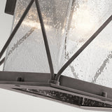 Close-up of the Argyle Outdoor 1 Light Medium Wall Light, featuring clear seeded glass encased in a sleek black metal frame with intersecting bars that emulate a weathered zinc appearance. The interior bulb emits a gentle glow, providing a warm ambiance.