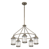 The Ashland Bay Outdoor 5 Light Chandelier in burnished bronze boasts a modern design with five lantern-style lights arranged in a circular pattern. Each light is adorned with a clear, seeded glass shade and suspended from a central rod, enhancing the ambiance of any outdoor space.