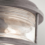 Close-up of the Ashland Bay Outdoor 2 Light Ceiling Flush in a weathered zinc finish. The clear seeded glass, which is ribbed and slightly frosted, showcases a visible bulb, giving the fixture a classic and sturdy look.