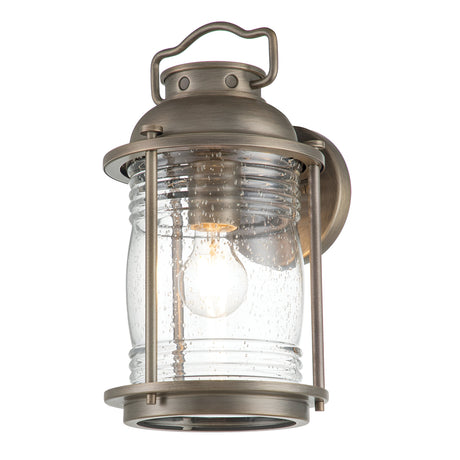 Introducing the Ashland Bay Outdoor 1 Light Medium Wall Lantern in Burnished Bronze. This vintage-style piece features a cylindrical design with clear seeded glass, showcasing a single exposed bulb that captures the essence of a classic lantern aesthetic.
