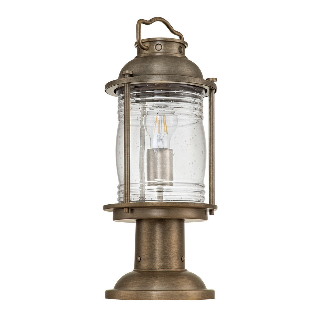 Introducing the Ashland Bay Outdoor 1 Light Medium Pedestal Lantern in burnished bronze, featuring a cylindrical glass enclosure accented with visible speckling and a robust base. Perfect for garden or porch illumination, this vintage-style lantern includes an LED Edison bulb to add a classic touch.