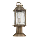 Introducing the Ashland Bay Outdoor 1 Light Medium Pedestal Lantern in burnished bronze, featuring a cylindrical glass enclosure accented with visible speckling and a robust base. Perfect for garden or porch illumination, this vintage-style lantern includes an LED Edison bulb to add a classic touch.