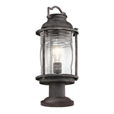 The Ashland Bay Outdoor 1 Light Medium Pedestal Lantern in a weathered zinc finish offers a vintage look with its clear, textured glass shade that houses an LED Edison-style bulb and is mounted on a cylindrical base.
