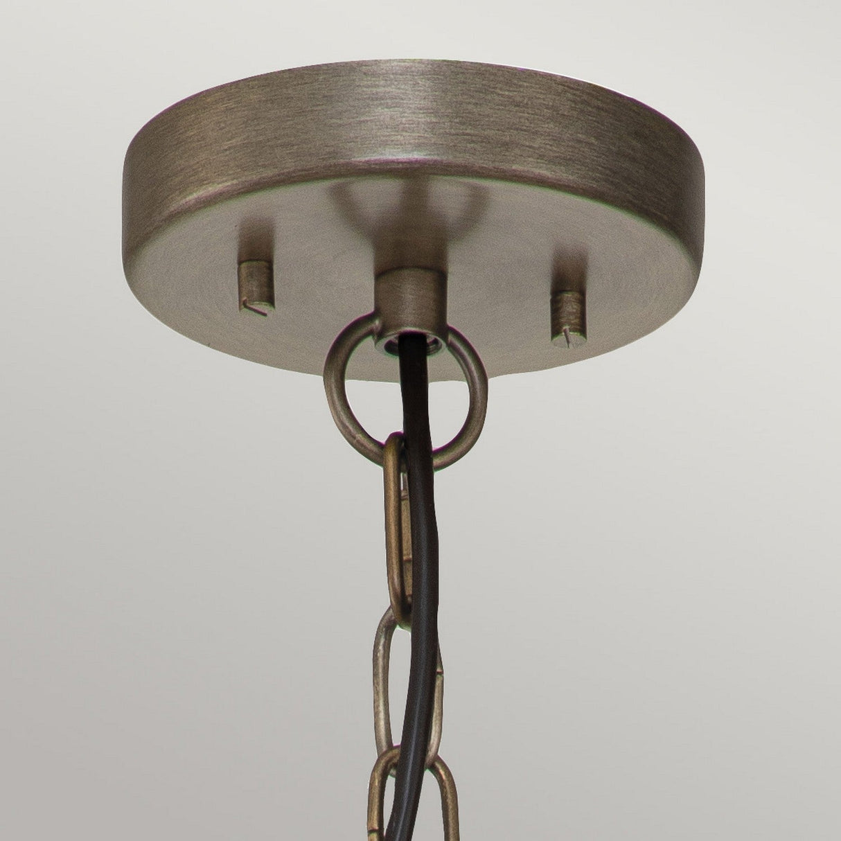 Close-up of the Ashland Bay Outdoor 1 Light Small Chain Lantern, showcasing a circular metal canopy with a rustic burnished bronze finish. The chain links hang elegantly from the canopy, attached to a sleek black cord, set against a light gray background.