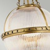 Get a close-up view of the Aster 3 Light Pendant - Brass, showcasing its vintage-style charm with ribbed glass domes and an antique brass finish. Decorative rivets enhance the metal band surrounding the glass, elegantly suspended by a chain.