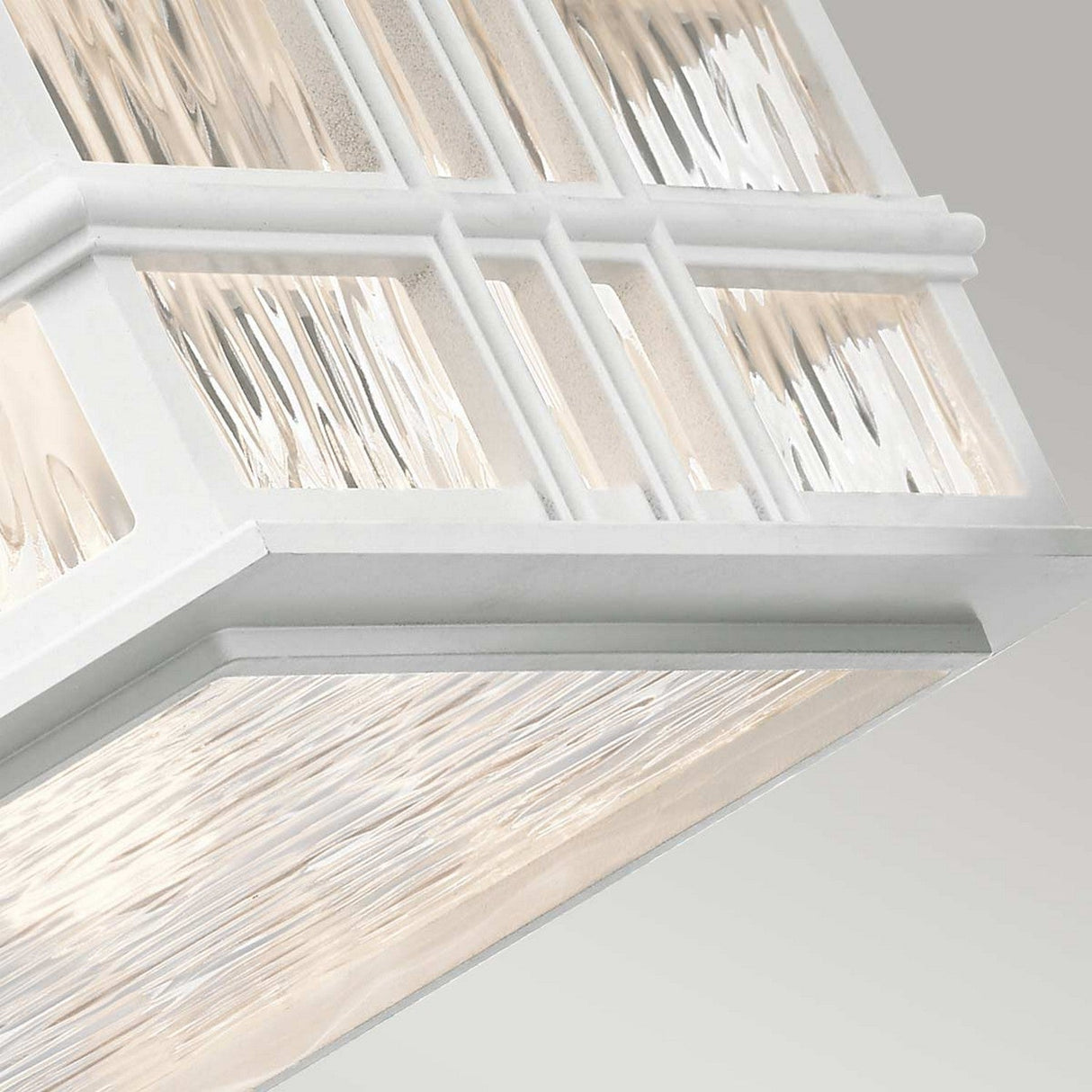 Close-up of the Beacon Outdoor 2 Light Flush in white, featuring a framed glass surface with a textured, wavy design. The transitional style provides a clean, modern aesthetic that subtly plays with light and shadow across its surface.