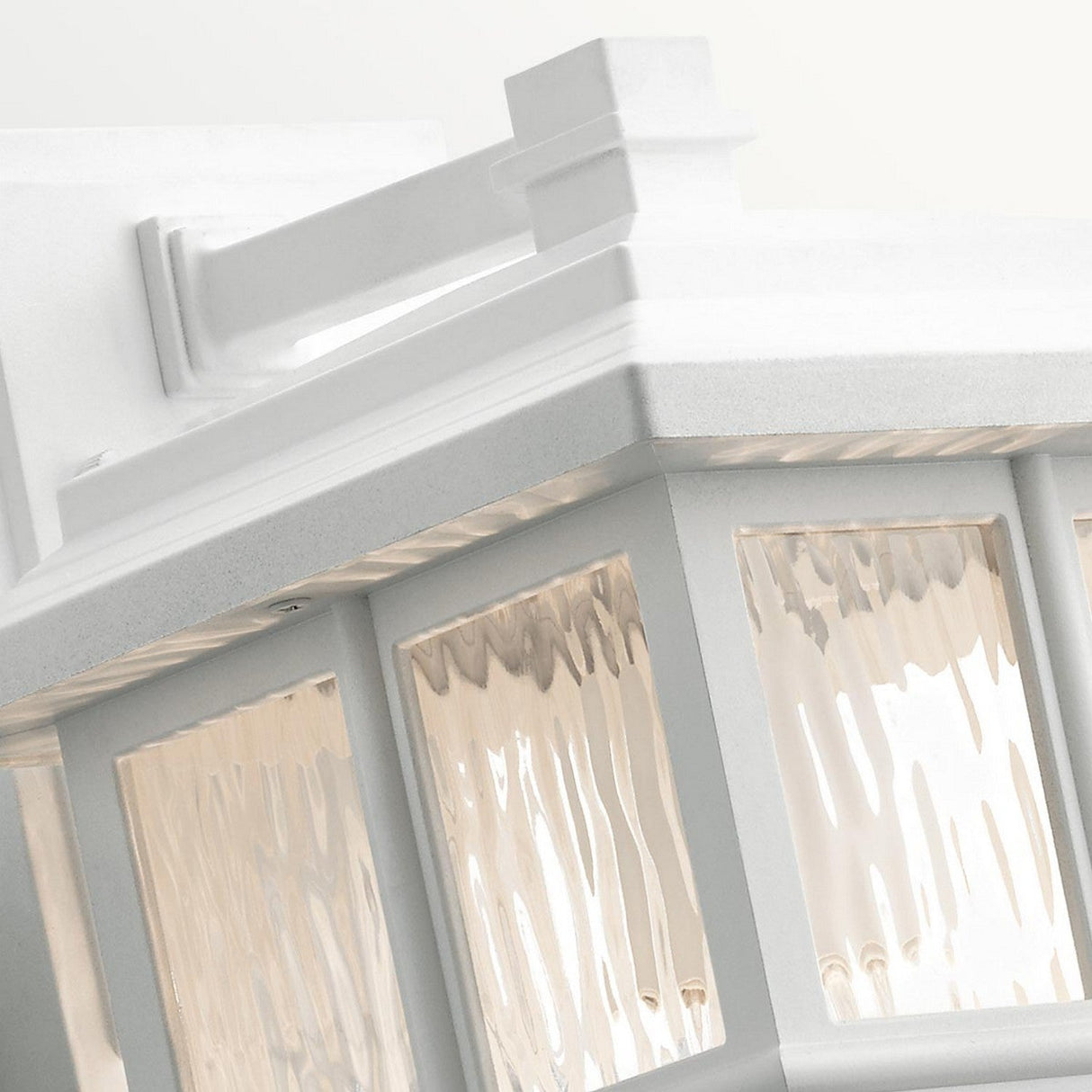 A close-up of the Beacon Square Outdoor 1 Light Medium Wall Lantern in white illustrates its craftsman design with transparent, textured glass panels. The clean lines and geometric structure emphasize the appeal of outdoor lighting by beautifully capturing light reflections on the glass.