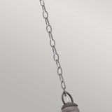 A detailed view of the Bridge Point Outdoor 1 Light Small Chain Light in weathered zinc, set against a light gray background. The chain is connected to an unseen fixture, showcasing a section of a metallic ring at the bottom that captures the rustic charm of an outdoor lantern.