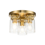 The Brinley 3 Light Flush - Brushed Brass ceiling fixture offers a modern design with vintage inspiration. It features three exposed bulbs beautifully encased in clear cylindrical glass shades, all mounted on a circular base.