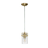 The Brinley 1 Light Mini Pendant in brushed brass showcases a clear glass shade and an exposed bulb, suspended gracefully from the ceiling by a cord. Its minimalist design elegantly highlights the vintage-style bulb.