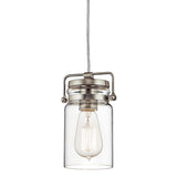 Experience vintage-inspired charm with the Brinley 1 Light Mini Pendant in Brushed Nickel, featuring a clear glass jar design and a visible vintage-style filament bulb inside, suspended by a cord and complemented by a brushed nickel mount.