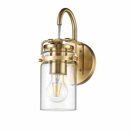 The Brinley 1 Light Wall Light in Brushed Brass showcases a visible LED bulb within its clear glass shade. This wall-mounted fixture features a curved arm connecting to a round brass wall plate, providing vintage-inspired lighting that harmonizes classic charm with modern appeal.