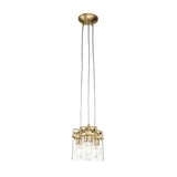 The Brinley 3 Light Pendant - Brushed Brass is a contemporary lighting fixture with three suspended bulbs housed in clear glass shades. It features a brushed brass finish, with three cords elegantly connecting to a round ceiling mount for an added touch of sophistication.