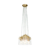 The Brinley 6 Light Pendant in brushed brass features a modern design that includes six clear glass shades, each suspended by multiple cords, showcasing light bulbs against a white background. Its elegant style flawlessly merges contemporary and industrial elements, evoking the essence of mid-century modern lighting.