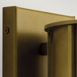 Close-up of a bronze-colored metal wall fixture with a visible screw on the left and a cylindrical component on the right. The matte finish adds sophistication, reminiscent of an outdoor lighting piece like the Camillo Outdoor 1 Light Medium Wall Lantern in natural brass. It's securely attached to a flat surface.