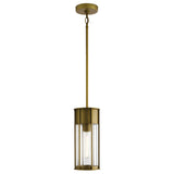 The Camillo Outdoor 1 Light Pendant in natural brass showcases a cylindrical design with clear seeded glass encasing a single vertical bulb. It boasts a sleek, modern appearance and is suspended by a long natural brass rod with a circular ceiling mount.