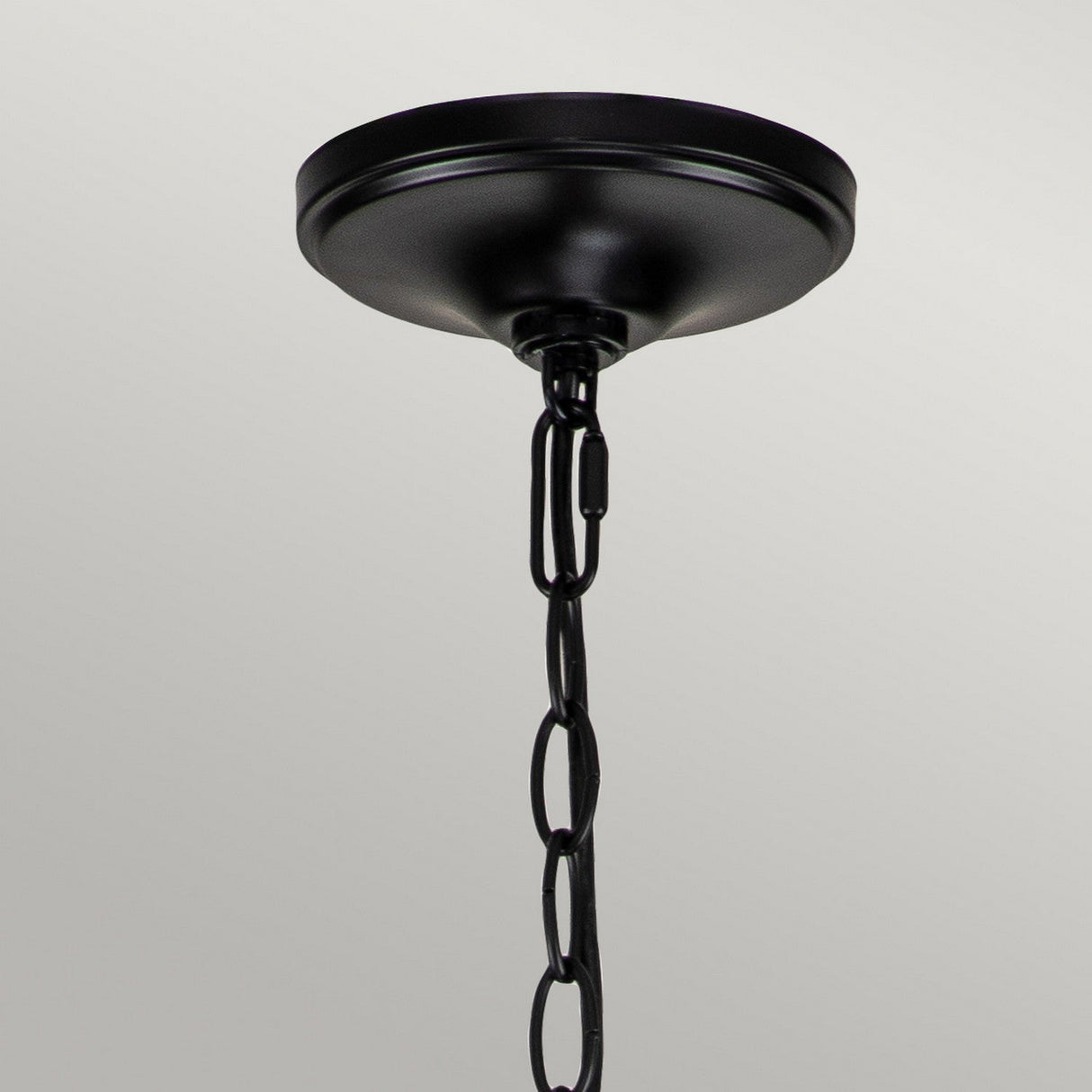 A stunning Capitol Hill 12 Light Chandelier in black, featuring a decorative chain, gracefully hangs against a simple white backdrop.