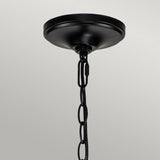 A stunning Capitol Hill 12 Light Chandelier in black, featuring a decorative chain, gracefully hangs against a simple white backdrop.