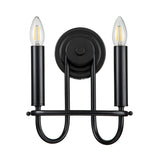 The Capitol Hill 2 Light Wall Light - Black showcases a contemporary black wall sconce equipped with two candle-style bulbs on cylindrical holders, all linked by an elegant, curved design. Its minimalist aesthetic and round base allow for simple wall installation while delivering sophisticated ambient lighting.