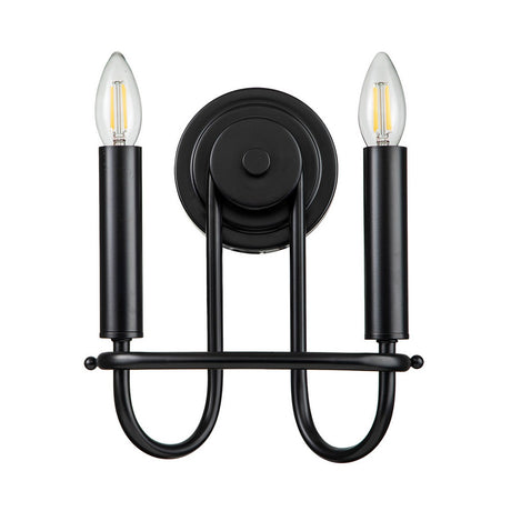 The Capitol Hill 2 Light Wall Light - Black showcases a contemporary black wall sconce equipped with two candle-style bulbs on cylindrical holders, all linked by an elegant, curved design. Its minimalist aesthetic and round base allow for simple wall installation while delivering sophisticated ambient lighting.