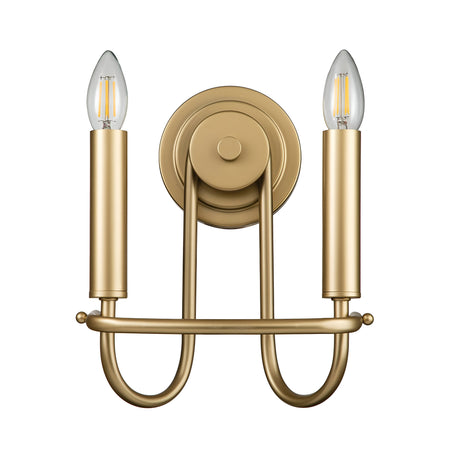 The Capitol Hill 2 Light Wall Light in Natural Brass showcases an elegant gold finish, featuring two vertical cylindrical arms that hold exposed filament-style bulbs. Its design includes a round wall mount and a horizontal U-shaped bar connecting the arms, making it perfect for home lighting.