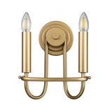 The Capitol Hill 2 Light Wall Light in Natural Brass features an elegant design with two candle-shaped LED bulbs. Its curved arms and circular base add a vintage charm, making it an exquisite addition to any home lighting setup.