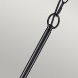 A striking close-up of the Capitol Hill 6 Light Chandelier - Black features its elegant rod attached to a ring, suspended by a chain against a light gray background. The sleek design of the chandelier rod creates a beautiful contrast with the textured links of the chain and ring.