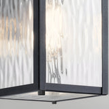 Close-up of the Cappanna 1 Light Outdoor Small Wall Lantern in textured black, featuring clear waterfall glass panels with a softly glowing light—ideal for stylish outdoor lighting.