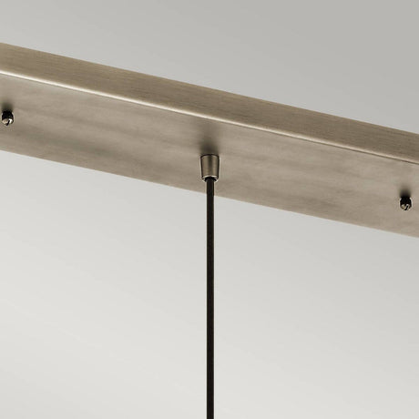 A close-up view highlights the elegant design of a ceiling-mounted light fixture, featuring the Ceiling Pan Rectangular Ceiling Plate in a sleek silver finish. A single thin rod extends from this rectangular plate, securely attached to the ceiling against a plain gray background, reminiscent of modern mini-pendant lights.