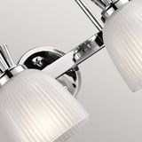 Close-up of the Cora 2 Light Wall Light, featuring a polished chrome base and two white, ribbed glass shades. This sleek and contemporary LED-compatible design is perfect for bathroom lighting or enhancing any interior decor.