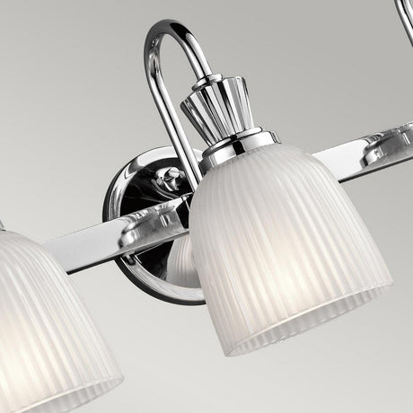 Detailed view of the Cora 3 Light Wall Light in polished chrome against a plain gray background. This IP44-rated fixture showcases a ribbed frosted glass shade and a chrome arm, embodying modern bathroom elegance.