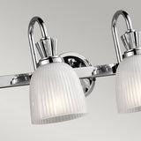 A detailed view of the Cora 4 Light Wall Light in polished chrome, showcasing its LED lamps with two frosted glass shades against a gray backdrop.
