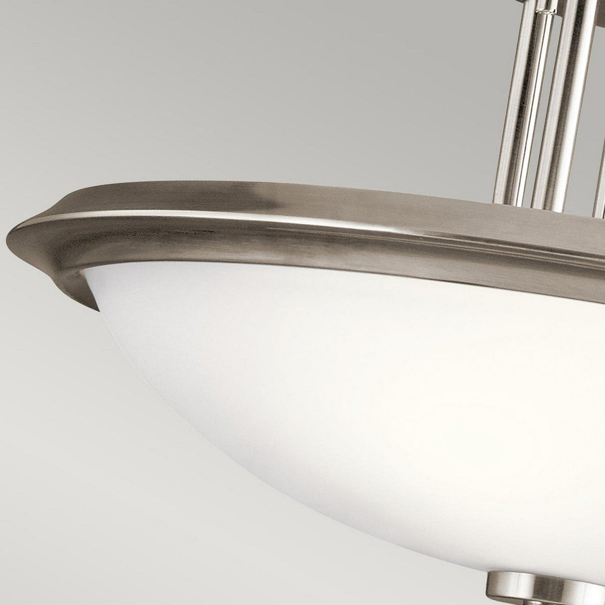 Close-up of the Dreyfus 3 Light Semi Flush - Silver ceiling light fixture showcasing a frosted glass bowl and sleek metal rim. This minimalist design radiates modern elegance with its smooth lines and contemporary aesthetic set against a neutral gray background.