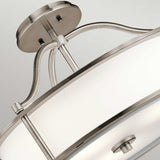 Close-up of the Emory 3 Light Duo-Mount Pendant/Semi-Flush in a circular design, featuring brushed nickel and silver finish. The contemporary style is highlighted by a translucent white cover with metal accents, mounted on the ceiling with a curved support.
