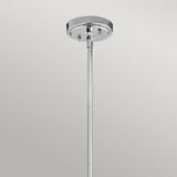 The Everly 1 Light Small Pendant - Chrome features a sleek chrome ceiling mount, where a rod elegantly extends downward to embody a sophisticated pendant lighting design. Its glossy round base shimmers against the plain gray background, highlighting the elegance of its chrome finish without any additional fixtures attached.