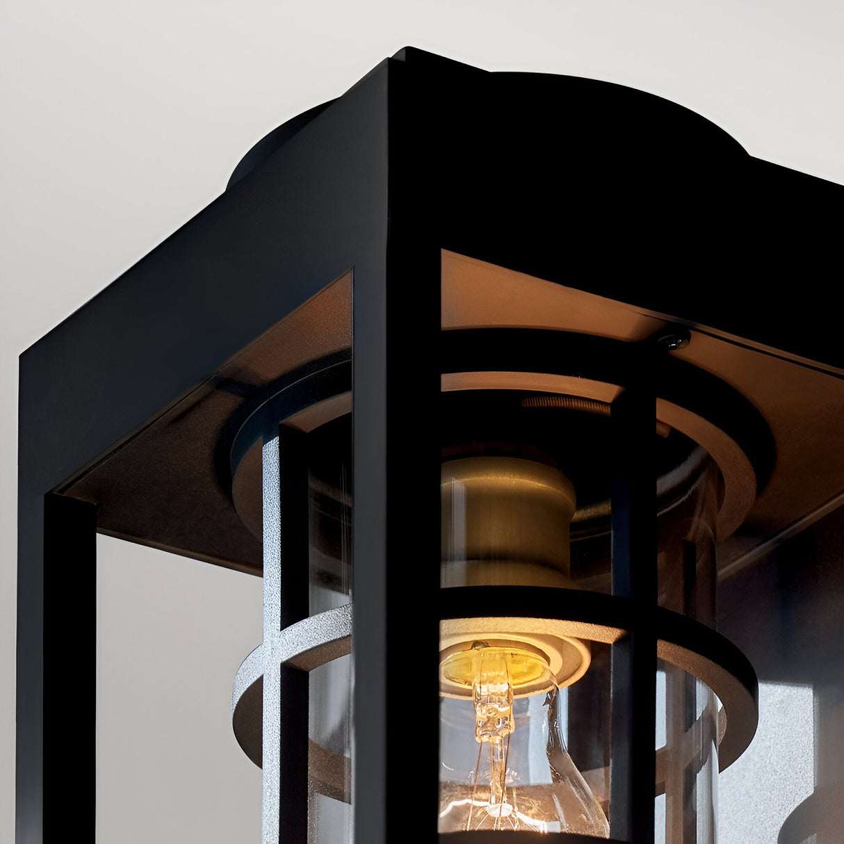Close-up of the Hone Coastal 1 Light Medium Outdoor Wall Lantern in black, with glass panels and a lit bulb—ideal weather-resistant lighting for your home’s exterior.