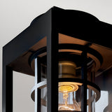 Close-up of the Hone Coastal 1 Light Medium Outdoor Wall Lantern in black, with glass panels and a lit bulb—ideal weather-resistant lighting for your home’s exterior.