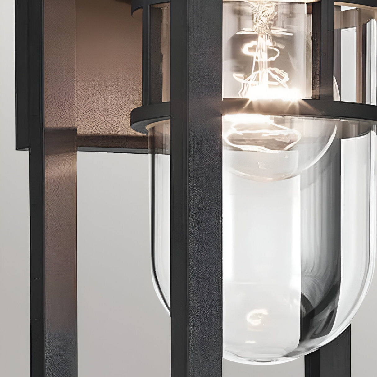Close-up of the Hone Coastal 1 Light Small Outdoor Wall Lantern in black, with a clear glass shade and visible bulb—an elegant, industrial-style fixture ideal for weather-resistant coastal lighting.