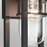 Close-up of the Hone Coastal 1 Light Small Outdoor Wall Lantern in black, with a clear glass shade and visible bulb—an elegant, industrial-style fixture ideal for weather-resistant coastal lighting.