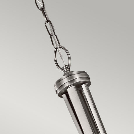 The Lacey 4 Light Large Pendant - Silver is a modern metallic silver fixture characterized by its vertical slats and a round top attached to a chain. Its striking, sleek double-shade design contrasts beautifully against the simple light gray background.