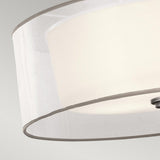 Close-up of the Lacey 4 Light Large Pendant in silver, featuring a modern design with a white cylindrical shade and a translucent outer layer against a neutral background. The pendant boasts sleek lines and an elegant double-shade design for a minimalistic style.