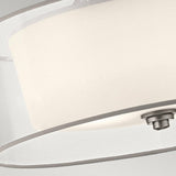 A close-up view of the Lacey 4 Light Semi Flush - Silver ceiling light fixture reveals a circular, brushed metal base with a polished silver finish. This fixture's sleek, minimalist design includes a white opaque double-shade structure that provides soft, muted lighting.