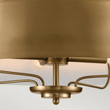 A close-up of the Luella 4 Light Duo-Mount Chandelier/Semi-Flush in brushed natural brass, showcasing its modern circular design with multiple outward-extending rods. The chandelier emits a warm glow, accentuating the smooth metallic surface against a soft, neutral background.