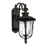 Luverne Outdoor 1 Light Medium Wall Lantern in rubbed bronze showcases a ribbed glass shade with intricate detailing, complete with curved arms and decorative patterns, making it an elegant addition to your exterior spaces.