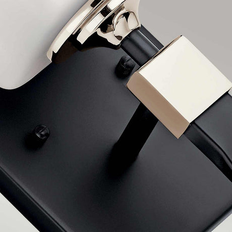 Close-up of the Marette 1 Light Wall Light - Black and Nickel, showcasing its modern design. It features a sleek black base, nickel elements, and an opal glass cylindrical shade, creating a minimalist and contemporary look against a soft gray background.