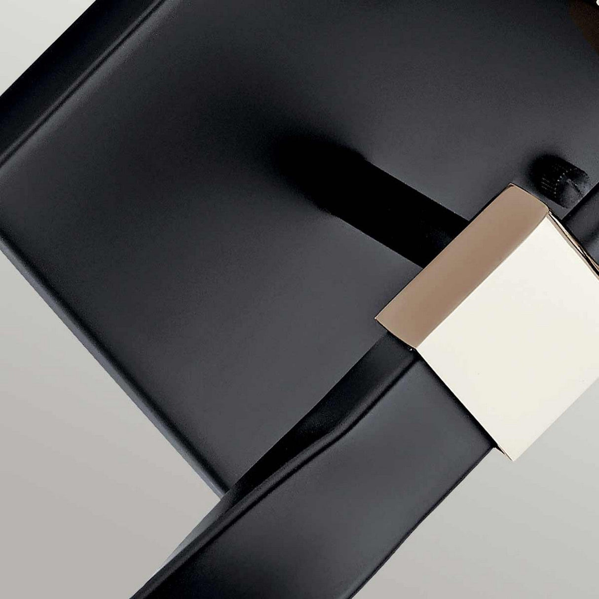 Close-up of the Marette 1 Light Wall Light in black with a nickel finish. The design is minimalist, enhancing the contrast between materials and colors. The background, resembling opal glass, showcases a subtle gradient that highlights the wall light's contemporary design aesthetic.