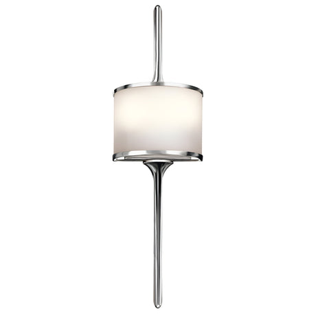 The Mona 2 Light Small Wall Light in Polished Chrome is a sleek and modern wall sconce featuring a cylindrical frosted glass shade with a metallic frame. Its minimalist design, highlighted by rods extending both above and below the light, incorporates G9 LED lamps for a contemporary touch to interior decor.