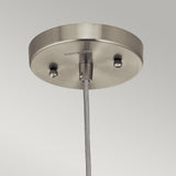 The Riviera-1 1 Light Pendant - Brushed Nickel features a brushed nickel ceiling canopy with a smooth finish. Its cylindrical fixture and vintage-inspired design, complete with a single cord that descends gracefully, embody minimalist elegance enhanced by two discreet screws.